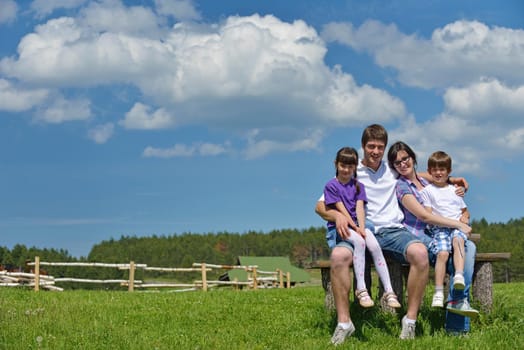 happy young family with their kids have fun and relax outdoors in nature with blue sky in background