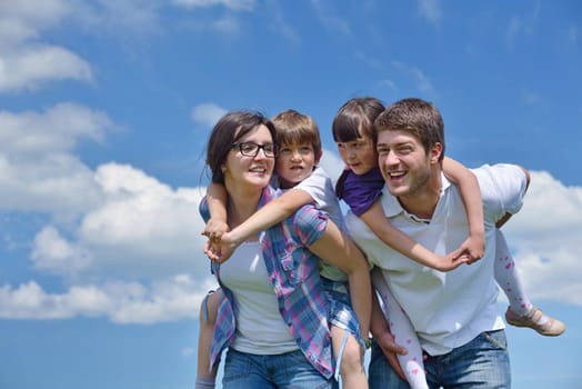 happy young family with their kids have fun and relax outdoors in nature with blue sky in background