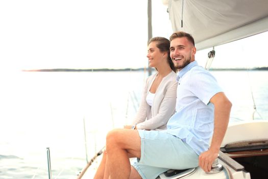 Attractive couple on a yacht enjoy bright sunny day on vacation.