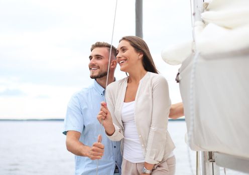 Attractive couple on a yacht enjoy bright sunny day on vacation.