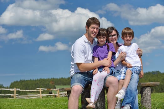 happy young family with their kids have fun and relax outdoors in nature with blue sky in background