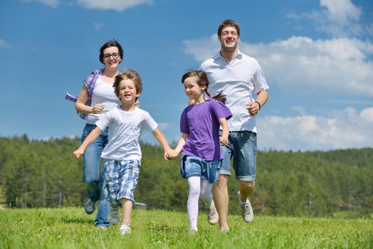 happy young family with their kids have fun and relax outdoors in nature with blue sky in background