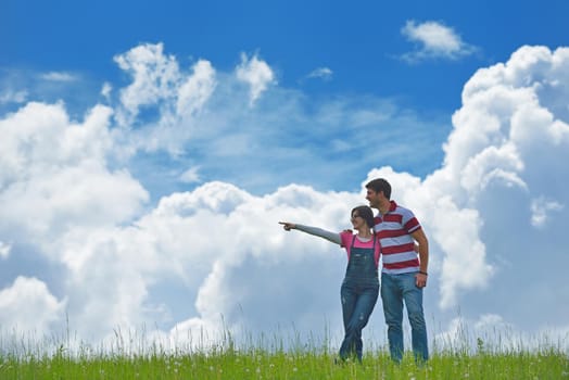 Portrait of romantic young couple in love  smiling together outdoor in nature with blue sky in background