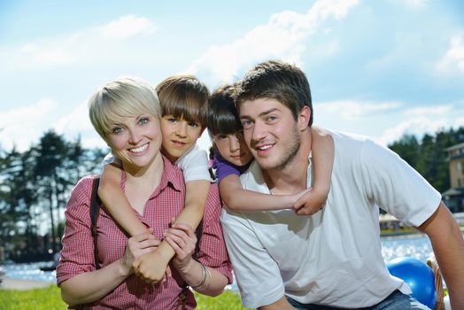 happy young family with their kids have fun and relax outdoors in nature with blue sky in background