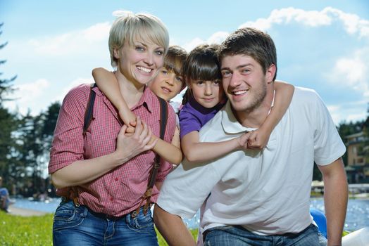 happy young family with their kids have fun and relax outdoors in nature with blue sky in background