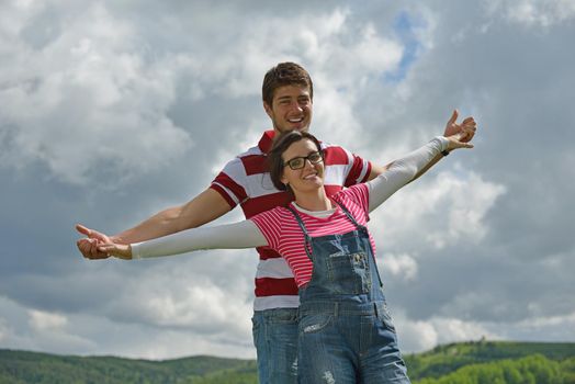 Portrait of romantic young couple in love  smiling together outdoor in nature with blue sky in background