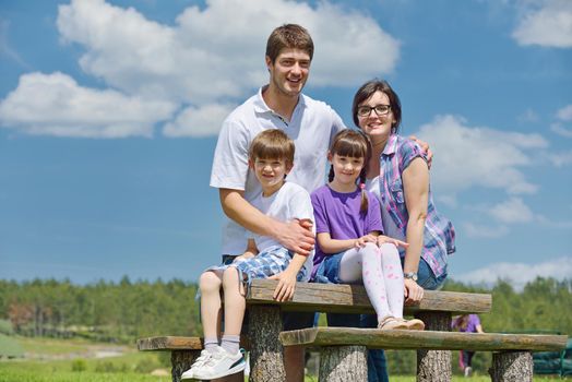 happy young family with their kids have fun and relax outdoors in nature with blue sky in background