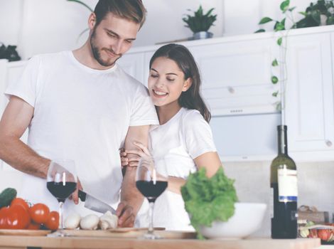 Beautiful young couple preparing a healthy meal together while spending free time at home.