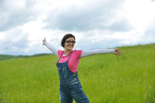 Enjoying the nature and life. Young woman arms raised enjoying the fresh air in green nature