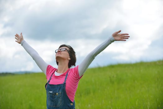 Enjoying the nature and life. Young woman arms raised enjoying the fresh air in green nature