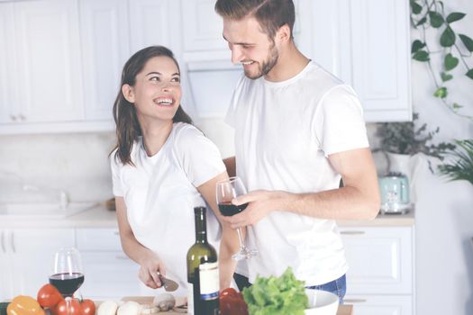 Beautiful young couple preparing a healthy meal together while spending free time at home.