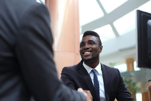 Business meeting. African American businessman shaking hands with caucasian businessman.