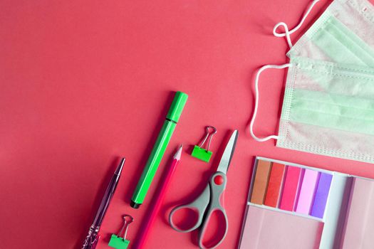 school supplies with medical face mask on a gray background. Protection of schoolchildren