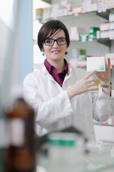 Happy cheerful pharmacist chemist woman standing in pharmacy drugstore