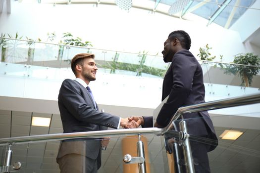 Bottom view. Business meeting. African American businessman shaking hands with caucasian businessman.