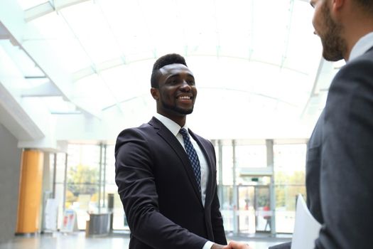 Business meeting. African American businessman shaking hands with caucasian businessman.