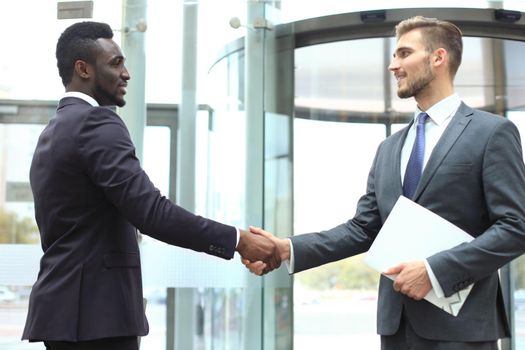 Business meeting. African American businessman shaking hands with caucasian businessman.