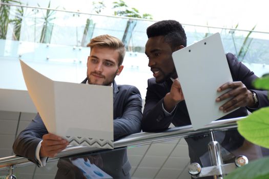 Bottom view. Two multinational young businessmen discussing at office during business meeting.