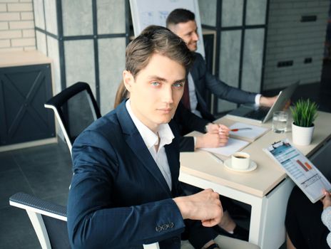 Businessman with colleagues in the background in office