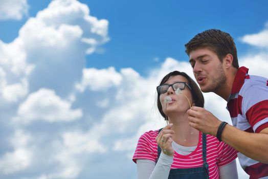 Portrait of romantic young couple in love  smiling together outdoor in nature with blue sky in background