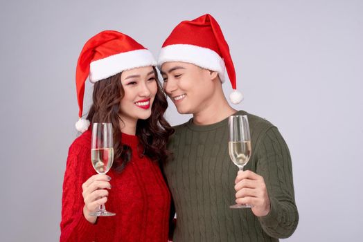 Asian couple wearing christmas hat and dress holding champagne glass