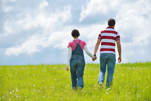 Portrait of romantic young couple in love  smiling together outdoor in nature with blue sky in background