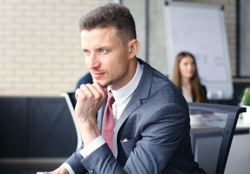 Businessman with colleagues in the background in office