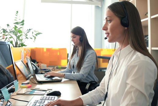 Attractive positive young businesspeople and colleagues in a call center office.