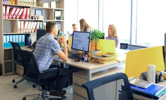 Group of young business professionals having a meeting. Diverse group of young designers smiling during a meeting at the office.