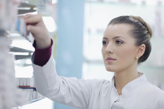 Happy cheerful pharmacist chemist woman standing in pharmacy drugstore