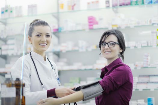 doctor checking blood pressure and heart rate in a hospital or in pharmacy with young female patient