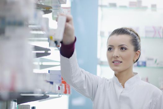 Happy cheerful pharmacist chemist woman standing in pharmacy drugstore