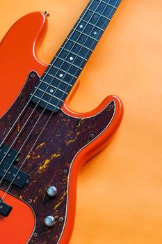 orange electric bass guitar on orange background with copy space