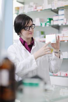 Happy cheerful pharmacist chemist woman standing in pharmacy drugstore