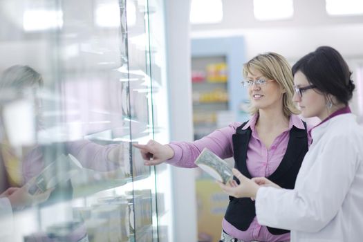 young pharmacist suggesting medical drug to buyer in pharmacy drugstore