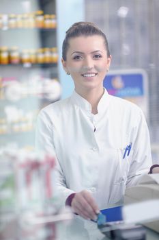 Happy cheerful pharmacist chemist woman standing in pharmacy drugstore