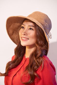 Happy thinking young woman looking up in straw hat on white background with empty copy space