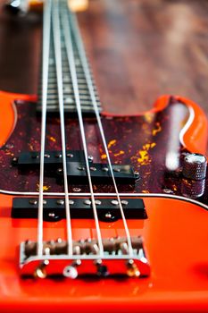 orange electric bass guitar on wood background with copy space