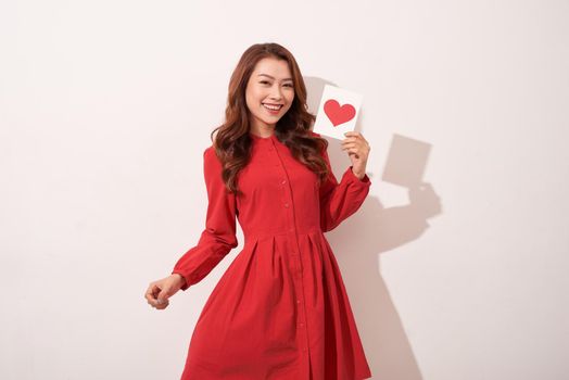 Lovely female with red heart isolated on gray background, celebration of Valentine day, romantic feelings, harmony and love concept