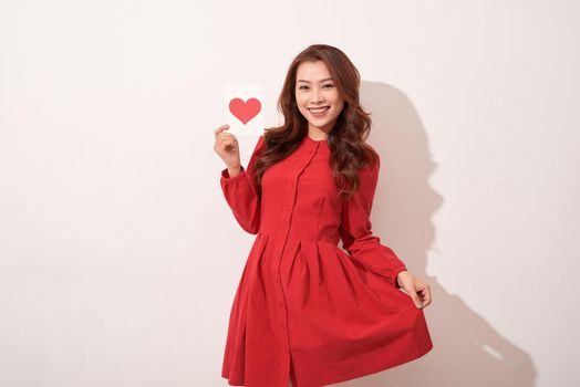 Lovely female with red heart isolated on gray background, celebration of Valentine day, romantic feelings, harmony and love concept