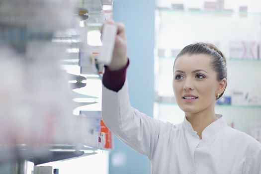 Happy cheerful pharmacist chemist woman standing in pharmacy drugstore