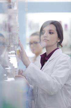 Happy cheerful pharmacist chemist woman standing in pharmacy drugstore