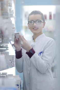 Happy cheerful pharmacist chemist woman standing in pharmacy drugstore