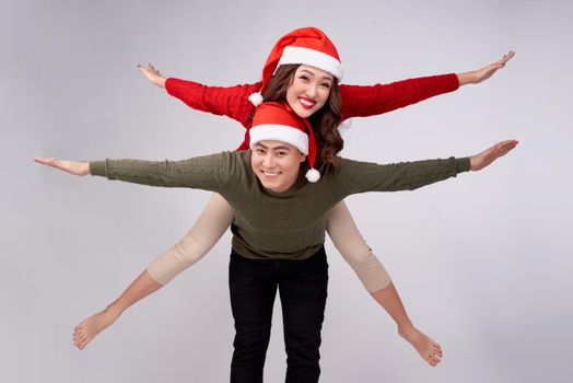 Beautiful love asian couple having piggybacking for Christmas holidays.