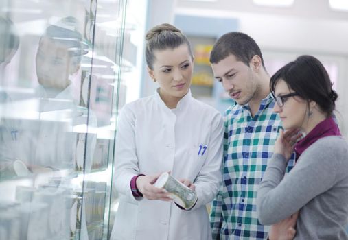 young pharmacist suggesting medical drug to buyer in pharmacy drugstore