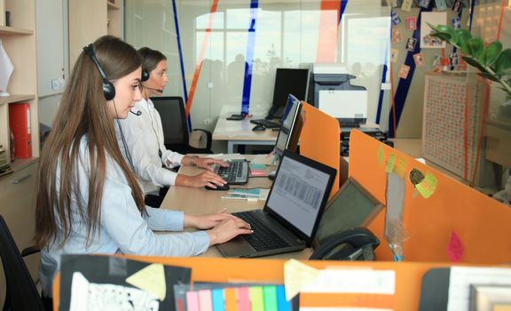 Attractive positive young businesspeople and colleagues in a call center office.