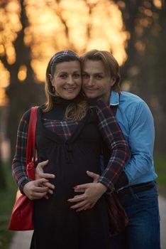 Happy and young pregnant couple have fun and relax outdoor