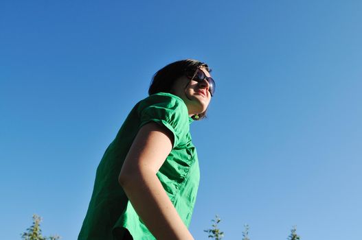 young beautiful brunette woman jump outdoor in fashion clothing and sunglasses