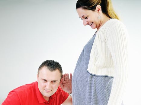 young family couple together in studio isolated on white. happy and waiting for baby