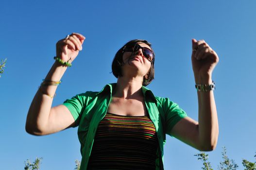 young beautiful brunette woman jump outdoor in fashion clothing and sunglasses